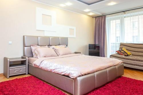 Un dormitorio con una cama grande y una alfombra roja en StudioMinsk 5 Apartments, en Minsk