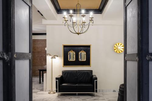a living room with a black chair and a chandelier at YIT Casablanca in Granada