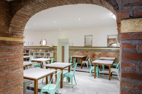 een boog in een restaurant met tafels en stoelen bij YIT Casablanca in Granada