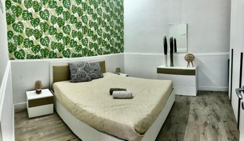 1 dormitorio con 1 cama y una pared verde y blanca en CASA VACANZA RESILIENZA, en Marsala