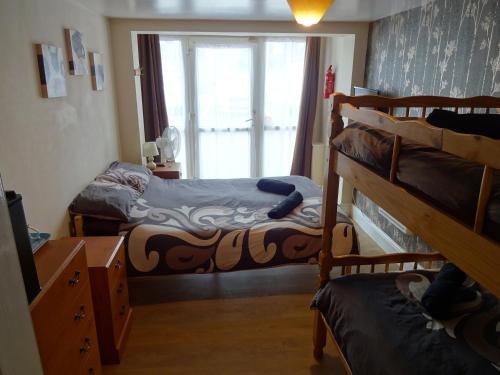 a bedroom with two bunk beds and a window at Travellers Rest Motel in Ingoldmells