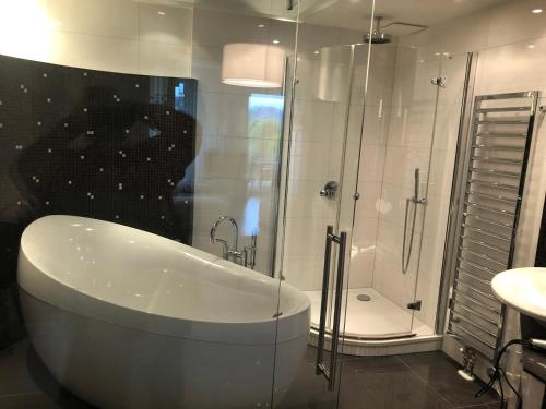 y baño con bañera, ducha y lavamanos. en Luxus Seeappartements, en Velden am Wörthersee