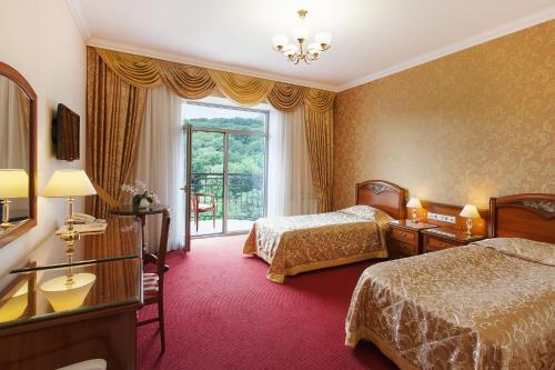 ジェレスノヴォツクにあるSanatoriy Bukovaya Roshchaのベッド2台と窓が備わるホテルルームです。