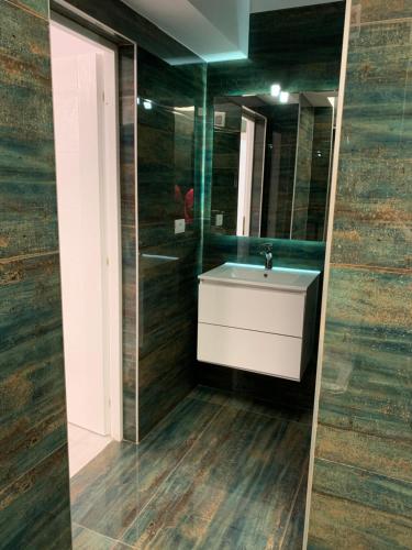a bathroom with a sink and a mirror at Apartament Alexandra in Mamaia