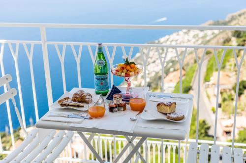 a white table with food and drinks on a balcony at Hotel le Rocce - Agerola, Amalfi Coast in Agerola