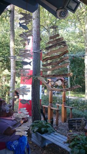 a garden with a tree with a wooden structure at SeaPark Hotel Wellness & Spa in Kołobrzeg