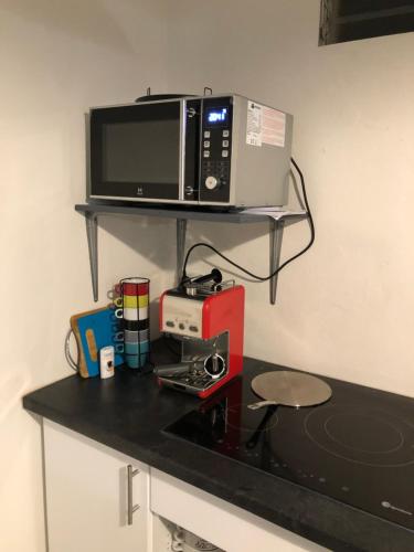 a microwave sitting on top of a kitchen counter at Belcourt1-lit queen size in Baie-Mahault