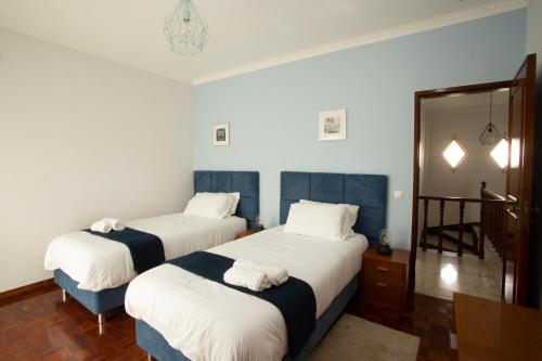 a hotel room with two beds and a mirror at Meriteluna Beach - Lisboa, Sintra e Cascais in Parede