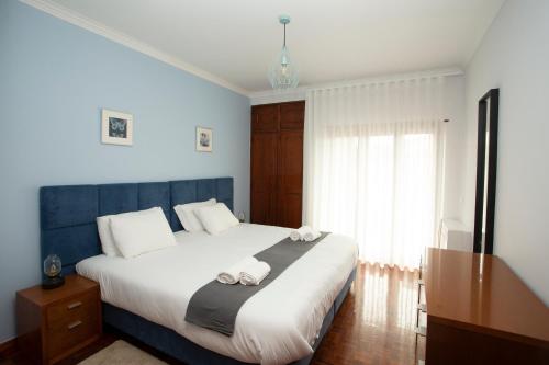 a bedroom with a large bed with towels on it at Meriteluna Beach in Parede