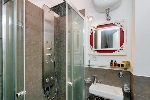 ein Bad mit einer Dusche, einem Waschbecken und einem Spiegel in der Unterkunft Vatican Art House in Rom