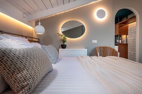 a bedroom with a large bed and a mirror at Horizon Apartments - Beachfront Luxury, by ZanteWize in Laganas