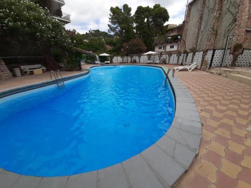 a large blue swimming pool in a yard at Casa Rural Porta Del Cel in Serra