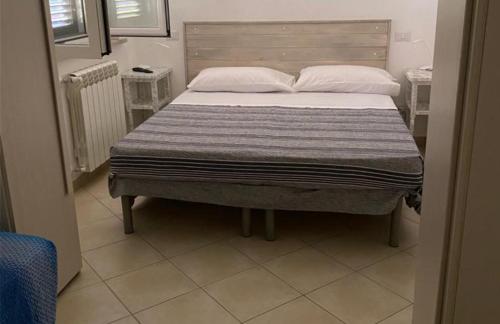 uma cama com duas almofadas num quarto em Da Nonna Laura al Circeo em San Felice Circeo