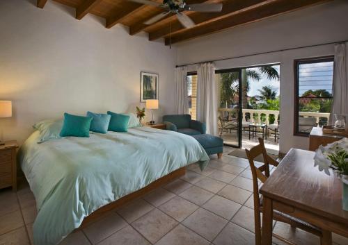 1 dormitorio con 1 cama y comedor con mesa en BELLAMARE, en Virgin Gorda