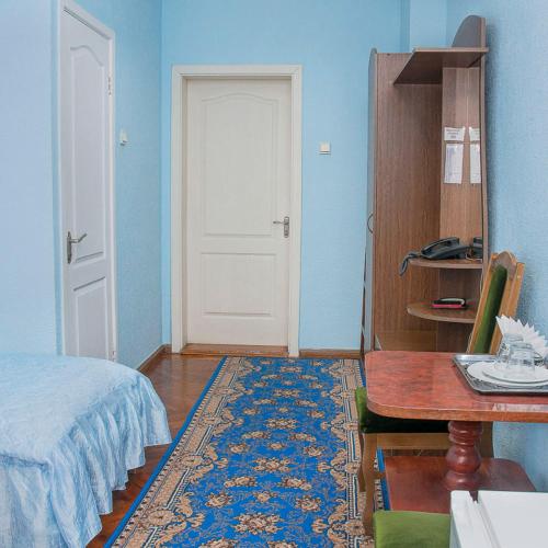 a room with a bed and a table and a door at Готельний комплекс Самікс in Kyiv