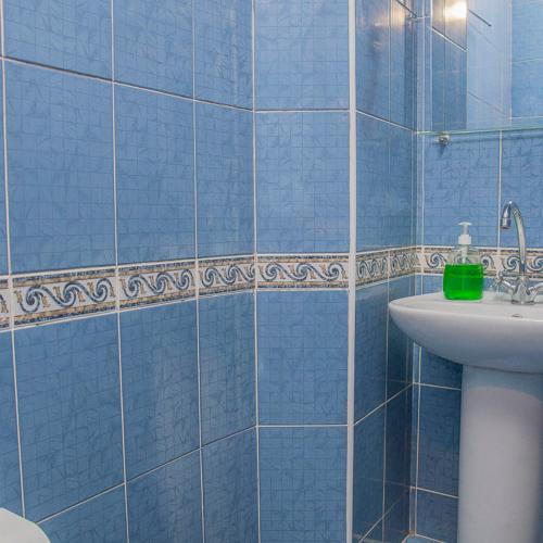 a blue tiled bathroom with a sink and a toilet at Готельний комплекс Самікс in Kyiv