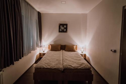 a bedroom with a bed with two lamps on it at Sunset Inn in Sîngeorgiu de Mureş