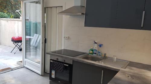 une cuisine avec un évier et une cuisinière dans l'établissement Cosy F2 proche de DisneyLand Paris, à Meaux