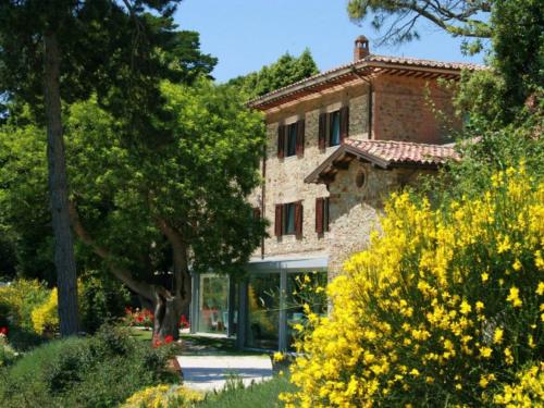 une maison en pierre au milieu d'un jardin dans l'établissement Tenuta Ponziani - Griffin's Resort, à Morrano