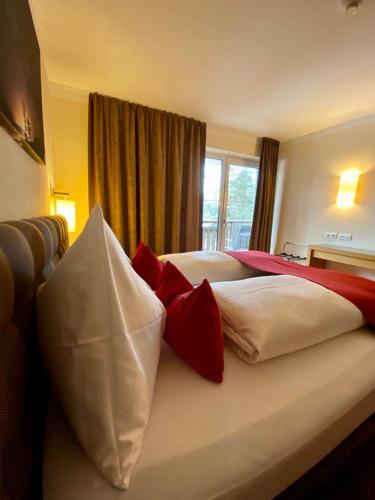a bedroom with two beds with red and white pillows at Apart-Elisabeth in Mieming