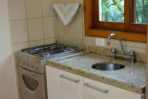 cocina con fregadero y fogones en LOCAR-IN GRAMADO - Residencial Maranello, en Gramado