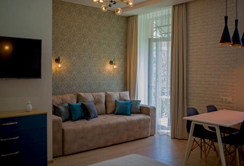 sala de estar con sofá marrón con almohadas azules en Modern apartmeents near Central Park, en Poltava