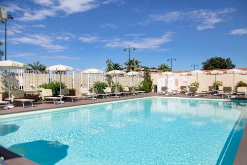 une grande piscine dans un hôtel avec des chaises dans l'établissement Grand Hotel, à Forte dei Marmi