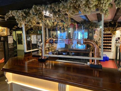 a bar with a wooden counter top in a store at The White Hart in Newenden