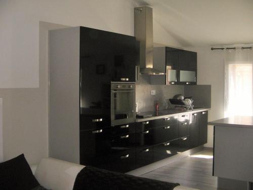 a kitchen with black cabinets and a stove at Black & White in Alignan-du-Vent