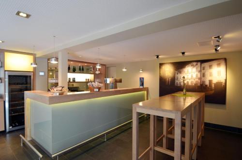 a kitchen with a bar with a wooden table at Wasserburg Rindern in Kleve