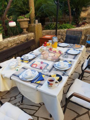 - une table blanche avec de la nourriture pour le petit-déjeuner dans l'établissement Villa Tiha, à Cavtat