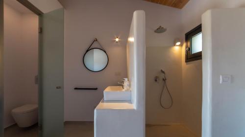ein Bad mit einem Waschbecken und einem Spiegel in der Unterkunft KEFI SPITIA in Simotáta