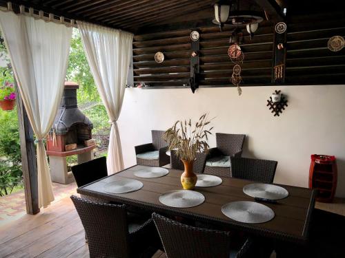 a dining room with a table and chairs and a fireplace at Casa Paunescu in Miloştea