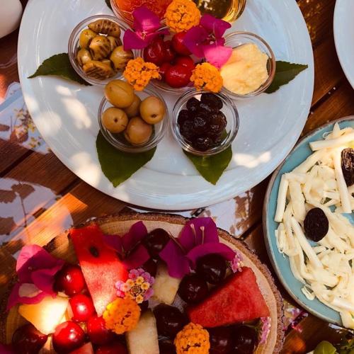 a table topped with two plates of food with fruit at Hotel Villa Monte in Cıralı