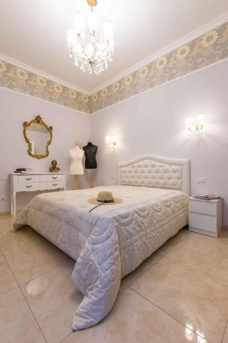a bedroom with a large white bed with a chandelier at Sant'Ivo Apartments in Rome