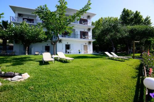 einen großen Garten mit Stühlen und einem Gebäude in der Unterkunft Mare Blu in Parga