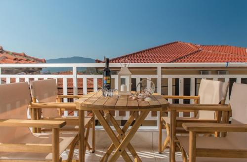 una mesa de madera con una botella de vino en el balcón en Hotel Olga en Sarti