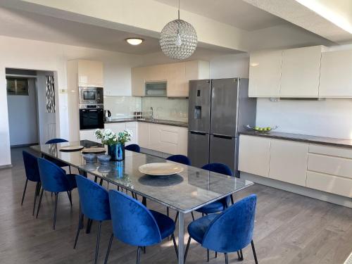 a kitchen with a dining table and blue chairs at Holiday Home Meri in Makarska