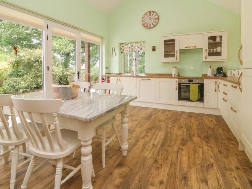 a kitchen with a table and chairs in a room at Langdale Barn in Okehampton