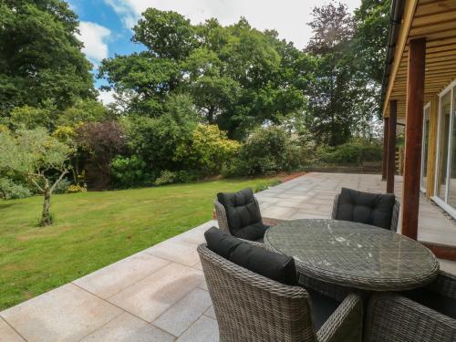 a patio with a table and chairs at Langdale Barn in Okehampton