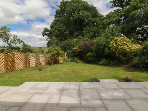 a garden with a lawn and a fence and a yard at Langdale Barn in Okehampton