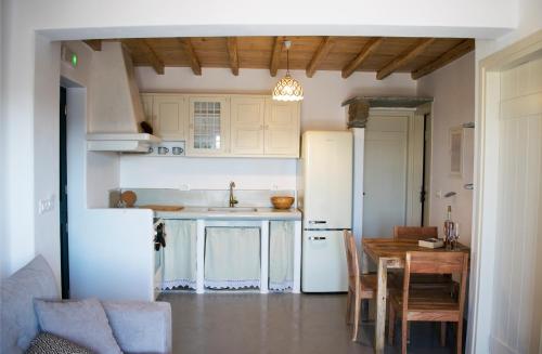 a kitchen with a table and a white refrigerator at Traditional suites in Chora Kythnos #4 in Kithnos