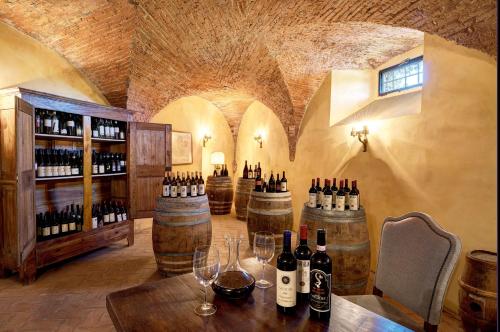 a wine tasting room with bottles and wine glasses at Villa La Massa in Bagno a Ripoli