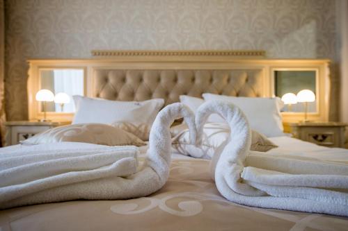 two swans towels sitting on top of a bed at Hotel Forum in Pazardzhik