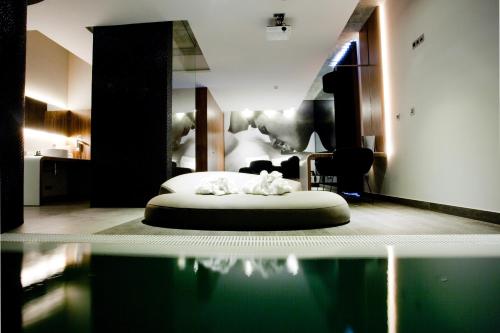 a room with a bed and a pool of water at Mood - Private Suites in Montijo