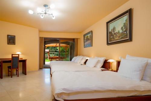 Una habitación de hotel con dos camas y un escritorio. en La Hacienda, en Vilvoorde