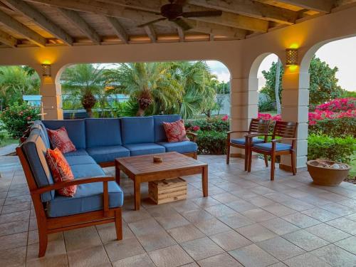 a porch with a blue couch and chairs on a patio at SANDCASTLE in Virgin Gorda