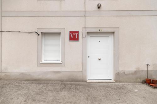 un edificio blanco con dos ventanas y una puerta blanca en Casa de la Abuela en el Camino de Santiago a Finiesterre, en Negreira