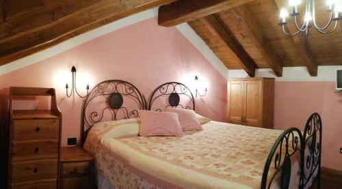 ein Schlafzimmer mit einem großen Bett und einer Holzdecke in der Unterkunft La Costa Di Gavedo in Gavedo