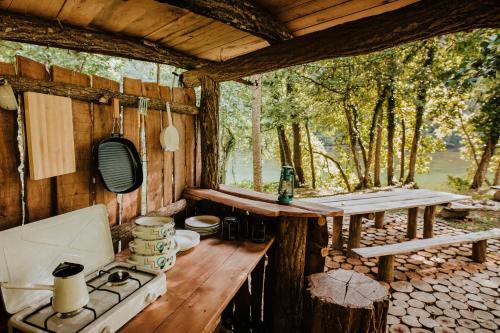 una cucina con tavolo e piano cottura in una cabina di Robinson camp Kupa - Juratovićki brig a Netretić
